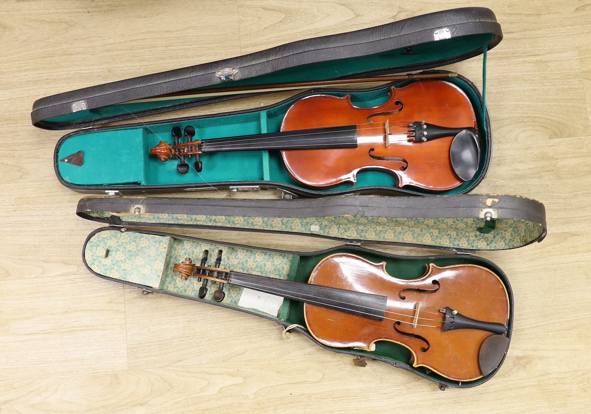 Two cased violins, one bow